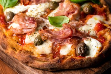 Prosciutto, mozzarella, domates sosu, zeytin ve kekik soslu nefis Roma pinsası. 