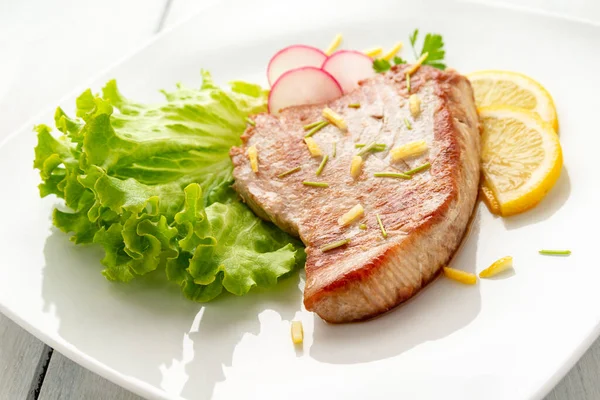 Taze salata ve limonla tavada pişirilmiş ton balığı bifteği. 