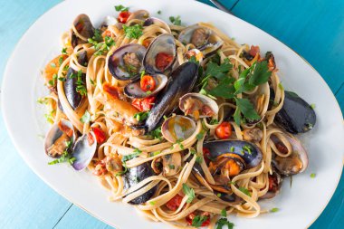 Delicious spaghetti with seafood and tomatoes on white plate 