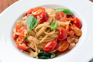 Kiraz domatesli makarna, peynir ve fesleğen yapraklı.