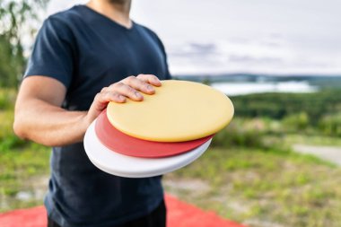 Park kursunda frizbi ekipmanı olan bir diskçi. Disgolf oynayan adam. Açık hava spor turnuvası. Finlandiya 'da yaz manzarası.
