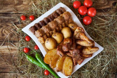 Izgarada pişmiş et, sebze ve mantar büyük bir tabakta yatıyor. Geniş bir grup Diner 'a ayarlayın. Restoranlar ve kafeler için menü kavramı.