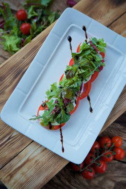 Yemek, domates ve soslu mozzarella peyniri. Restoranda yemek servisi..