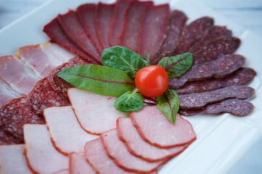 Restoranda çeşitli et ve sosisleri bir tabakta kesiyorlar..