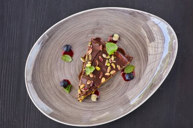 İçinde karamelli fındıkla süslenmiş lezzetli bir çikolatalı pasta. Yemek stili ve yemek tarifleri kavramı.