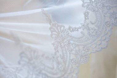 Dantelli ve nakışlı, kumaştan gelinliklerle süslenmiş.