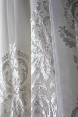 Dantelli ve nakışlı, kumaştan gelinliklerle süslenmiş.