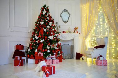 Noel ağacı bir ev odasında süslenir. Noel ağacının üzerinde kırmızı ve beyaz renkli toplar. Kutlama ve eğlence konsepti.