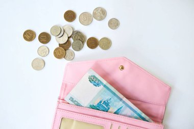 Rusya 'nın 1000 rublelik banknotu, çeşitli değerlerde dağınık paraların yanında, pembe bir kadının çantasında. Tasarruf ve tasarruf kavramı, küçük bir miktar finans.