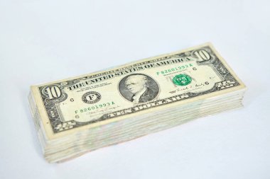 10 dolarlık banknotlar beyaz bir yüzeyde duruyor, büyük bir tomar para. Ekonomi ve bankacılık sistemi, finansman ve bütçe hesapları kavramı.