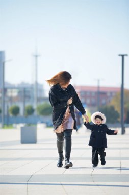 Anne ve kızı parkta yürüyor.