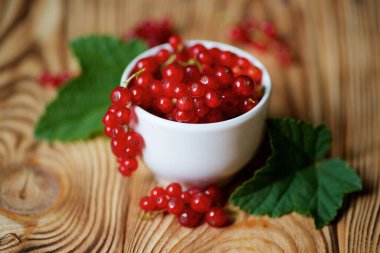 A white Cup is red currants and leaves. Fruits and berries of the summer season. 