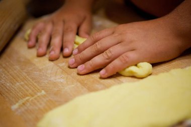 Children's hands knead the dough for the cake. The kid chef cooks and bakes.