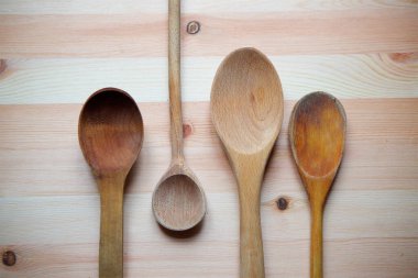 Wooden village spoons four pieces lie on the wooden surface of the table.