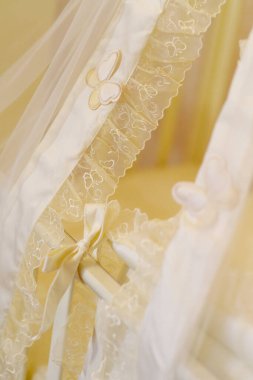 A canopy for a baby cot in a classic style. Beige natural fabric. Protection for the child. The concept of motherhood and childhood.