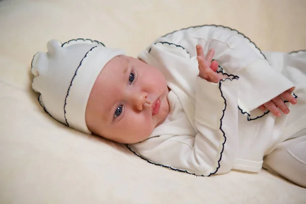 小新生男婴穿着白衣躺在白色毛毯的背景下 — 图库照片