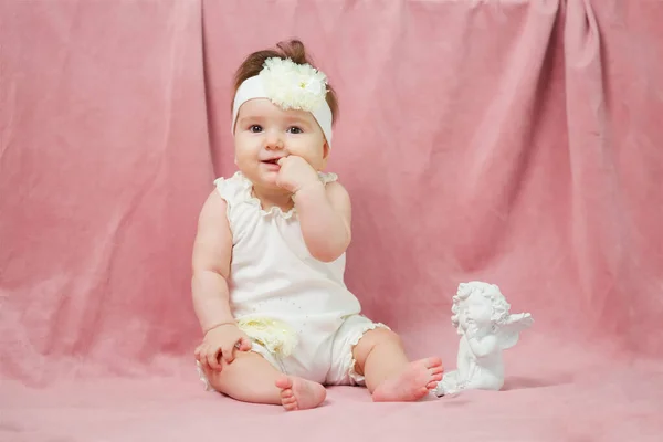 Little Girl Sitting Pink Background White Clothes Next Statue Angel — Stock fotografie
