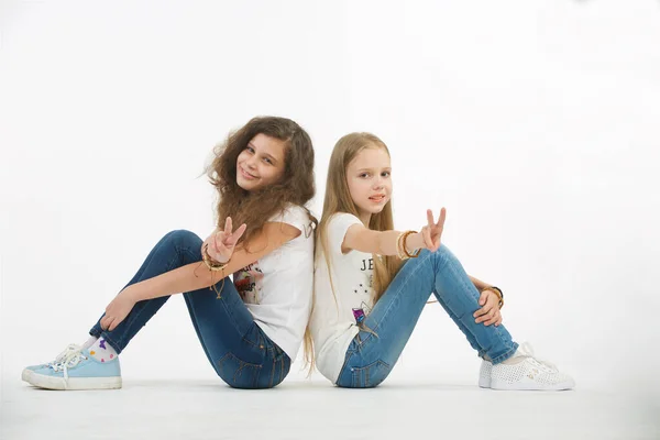 Dwie Nastoletnie Przyjaciółki Siedzą Białym Tle Dziewczyny Patrzą Kamerę Pokazują — Zdjęcie stockowe