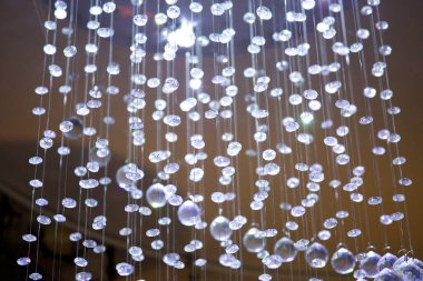 İplikler, ipler ve kristal detaylı kurdeleler tavandan sarkan bir perde gibi. Tatil için dekor ve dekorasyon..