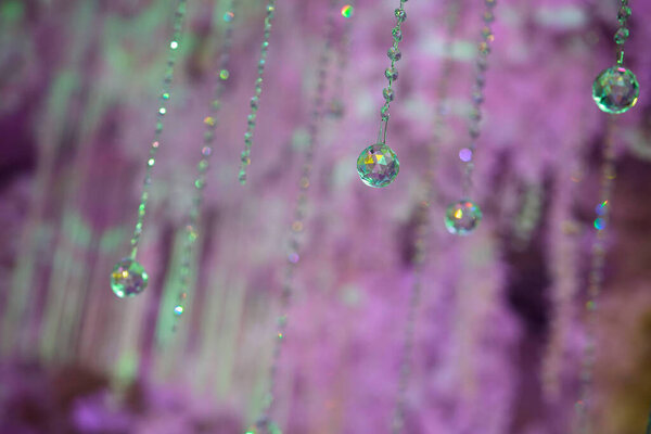 Threads, ropes and ribbons with crystal details hang from the ceiling like a curtain. Decor and decoration for the holiday.