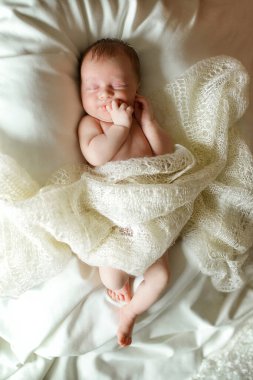 Yeni doğmuş bir bebek, bebek yumuşak bir battaniyenin üzerinde karnının üstünde uyuyor.