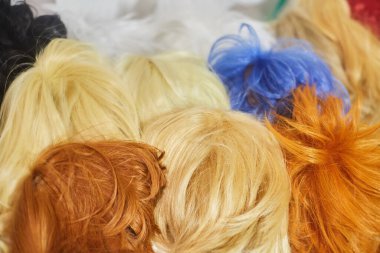 Çok renkli perukların saç dokusu, sentetik ve doğal. Güzellik ve moda endüstrisi.