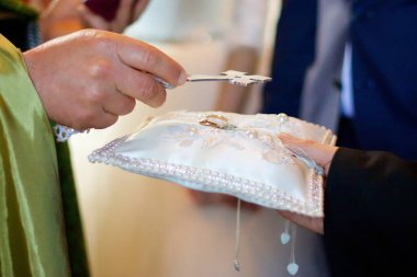 Düğün töreni sırasında kilisede bir Hıristiyan rahip elinde bir alyans tutuyordu..