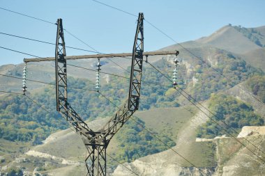 Dağlık bir bölgede bulunan kablolardan elektrik aktarımı için yüksek voltajlı bir kule. Ulaşılması zor bölgelerde enerji endüstrisi.