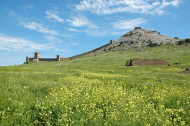 Dağdaki antik taş ortaçağ kalesi ve etrafındaki duvarlar.