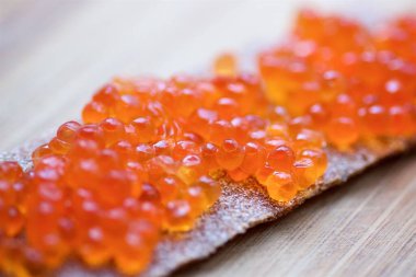 Tahtadaki ince düz ekmek ve kırmızı havyar..