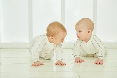 İki yeni doğmuş bebek beyaz bir odada. Çocukluk ve annelik kavramı.