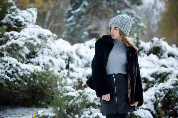 Ένα Κορίτσι Μοντέρνα Χειμωνιάτικα Ρούχα Στέκεται Στο Φόντο Ενός Χειμερινού — Φωτογραφία Αρχείου