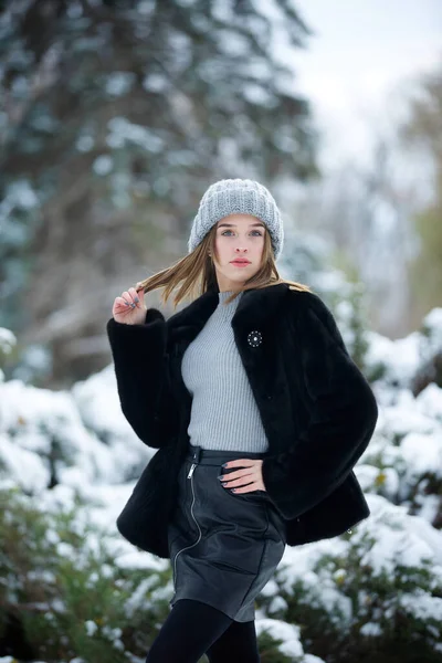 Ένα Κορίτσι Μοντέρνα Χειμωνιάτικα Ρούχα Στέκεται Στο Φόντο Ενός Χειμερινού — Φωτογραφία Αρχείου