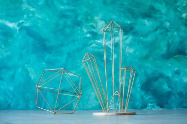 İç dizayn, turkuaz bir duvara karşı sıradan tarzda modern altın renkli metal tel koleksiyonu şeklinde. Heykelin şekli mineraldir..