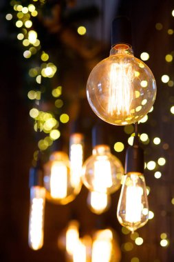 Eski moda iç mekanların duvarında kabloların asılı olduğu klasik lambalar. Arka planda parıltı.