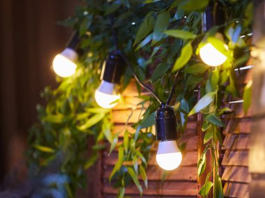 Eski moda iç mekanların duvarında kabloların asılı olduğu klasik lambalar. Arka planda parıltı.