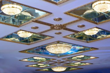 Ayna tavanında kristal ve camdan yuvarlak bir avize..