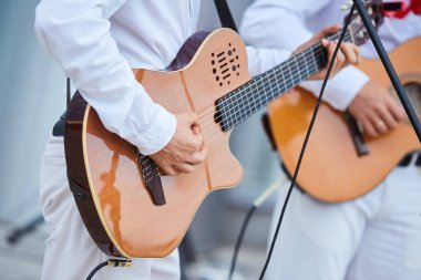 Bir erkek müzisyenin ellerinde telli müzik aleti akustik gitar. Kültür ve sanat kavramı.