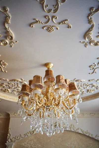 Ceiling chandelier of classic vintage style shape made of crystal and glass with candle shaped lamps.