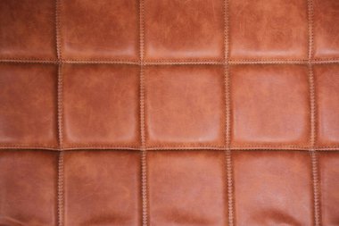 Kumaşın dokusu, tasarımın arka planı olarak kahverengi hakiki deriden yapılmıştır..