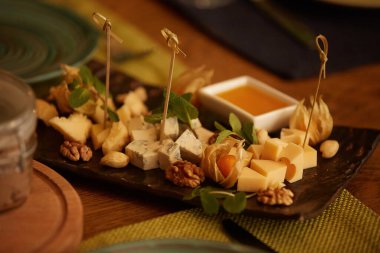 Tabaktaki peynirin farklı çeşitleri. Restoranlar ve kafeler için menüler. Çeşitli malzemelerle dekorasyon.