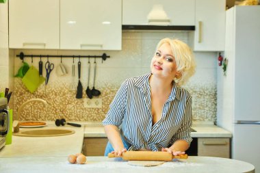 Mutfakta bir ev hanımı pişirmek için hamur topluyor. Tarifler kavramı.