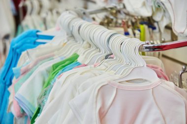 Eşyalar mağazadaki pencereye asılıyor. Çocuk kıyafetlerinin üretimi ve satışı. Tekstil endüstrisinde iş.