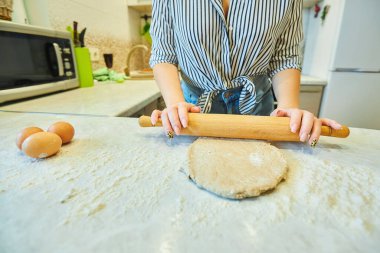 Gri un ve hamuru bir kızın ellerine vermek için merdane. Un ürünlerinin hazırlanması için ham ürünler. Organik yiyecekler.