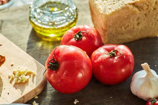 Red tomatoes, bread, garlic and other spices in the assortment. Cooking at home or in a restaurant. Organic food products.