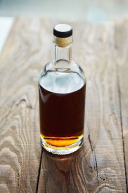 Alkolik içki konyağı ya da tahta bir masanın üzerinde cam bir şişede viski..