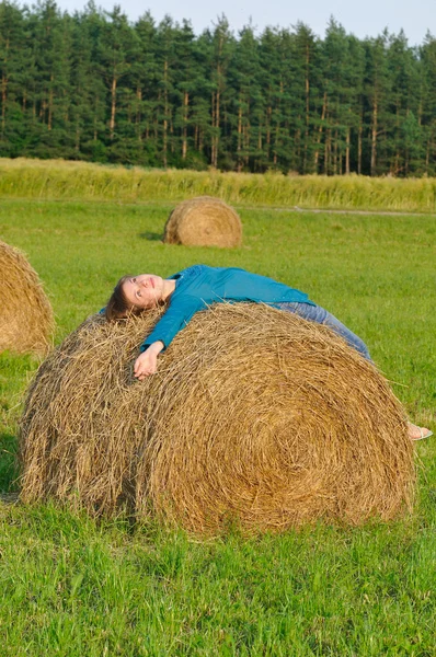 女孩躺在干草堆上 — 图库照片