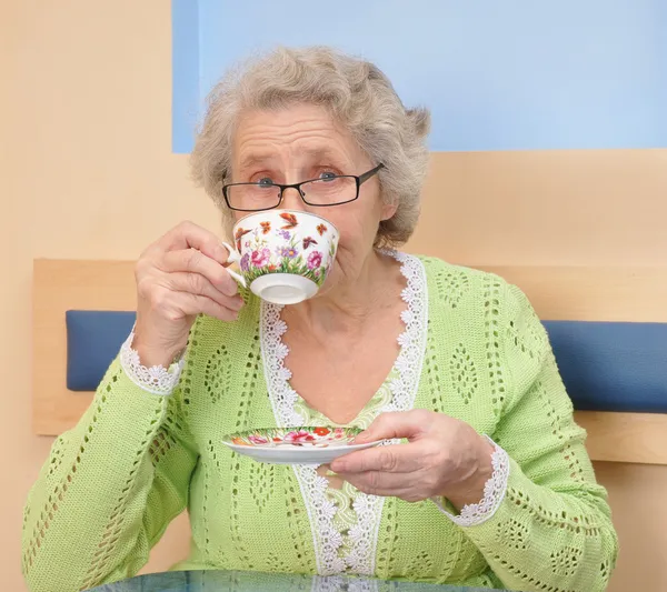 Oude vrouw genieten van koffie of thee beker — Stockfoto