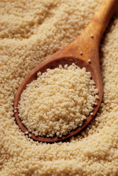 Couscous and wooden spoon — Stock Photo, Image