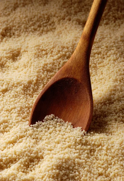 Couscous and wooden spoon — Stock Photo, Image